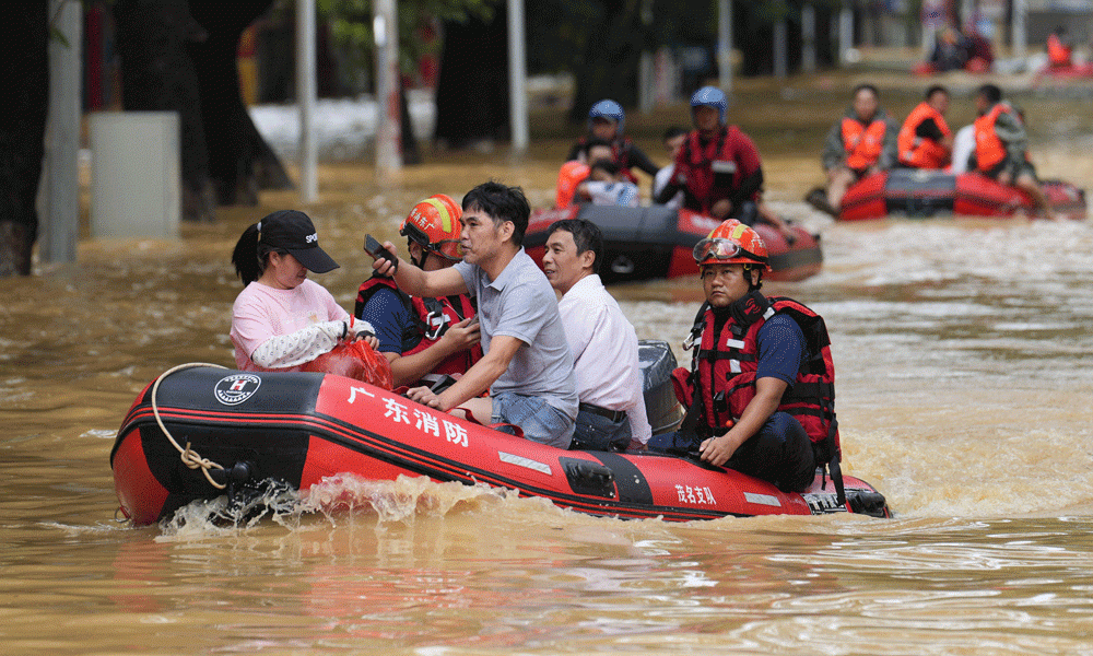 Rescue workers carry residents on boats through a street flooded by heavy rains from Typhoon Sanba in Maoming, in China’s southern Guangdong province on October 21. Photo : AFP