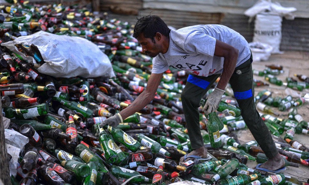 In this photograph taken on January 29, 2024, a worker collects empty beer bottles for recycling at a unit in Bengaluru. Photo : AFP