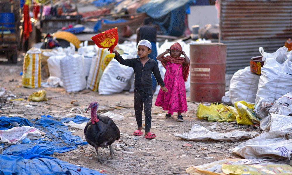 In this photograph taken on January 29, 2024, Children walk through the plastic waste at a recycling unit in Bengaluru. Photo : AFP