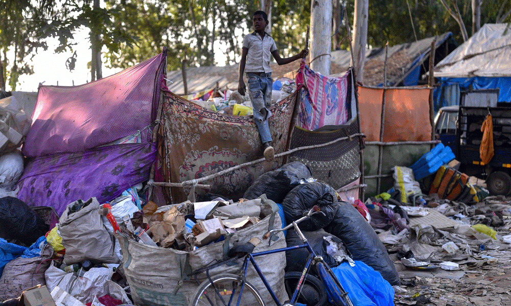 In this photograph taken on January 29, 2024, a boy stands on a pile of plastic wastes at a recycling unit in Bengaluru. Photo : AFP