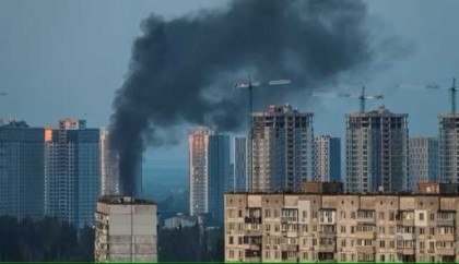 Debris falling on Kyiv, building on fire as air defence active